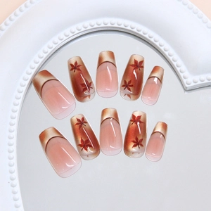 Cat eye press-on nails with autumn maple leaf design and glossy French tip finish