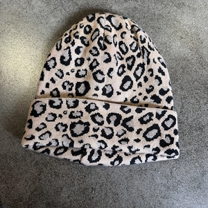 Detailed texture of thick leopard print knit hat with soft beige and black yarn fibers