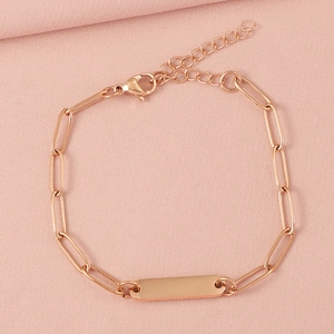 Detail view of rose gold stainless steel paperclip chain bracelet on pink fabric background