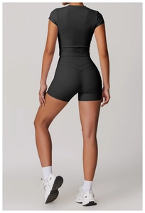 Vista posteriore del set da yoga nero con top corto aderente e pantaloncini a vita alta sportivi