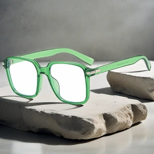 Modern oversized square transparent green eyewear frame on a minimalist stone base