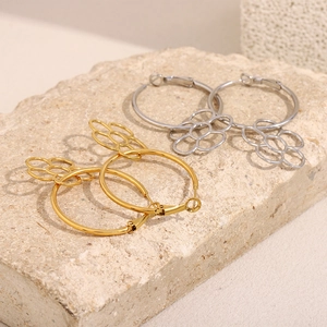Détail de boucles d'oreilles créoles dorées et argentées avec pendentifs fleurs évidées