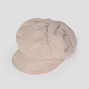 Gros plan détaillé d'un bonnet beige montrant la texture gaufrée et les coutures plissées