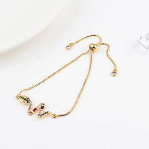 Detail of adjustable gold snake bracelet with colorful zircons and pull-cord clasp