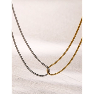 Macro shot of interlocking gold and silver dual-tone flat snake bone chains in 18k gold