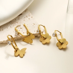 Detail view of gold butterfly and flower titanium steel earrings with embedded crystals
