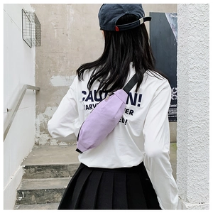 Rear view of model wearing a lavender canvas waist bag against a minimalist staircase