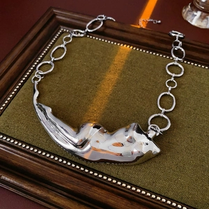 Détail macro du pendentif argenté irrégulier sur présentoir en velours vert