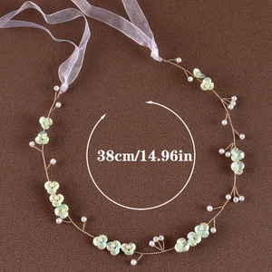 Detailed view of handmade bridal headband with white pearls and green flowers, length 38cm