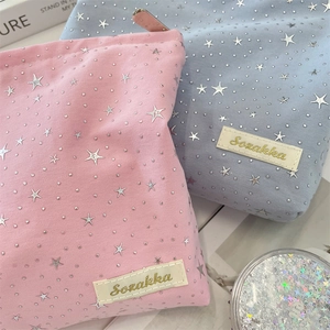 Detailed macro view of large capacity star sequin makeup bags in pink and blue canvas