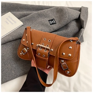 Detail view of brown punk rivet shoulder bag with silver metal studs and buckle strap