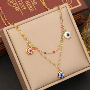 Double-layered gold necklace with colorful beads and triple evil eye pendants