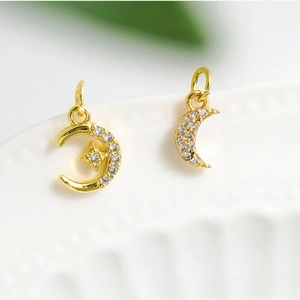 Détail de pendentifs lune et étoile plaqués or 18 carats sertis de zircons micro-pavé