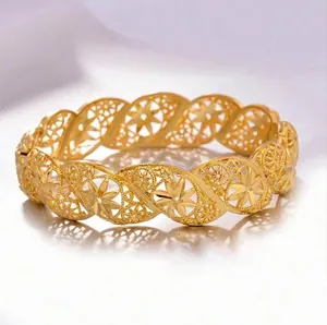 Detailed view of hollow floral patterns on a vintage golden wavy bangle for women