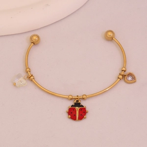 Gold open bangle featuring ladybug enamel, frosted butterfly, and heart diamond charms