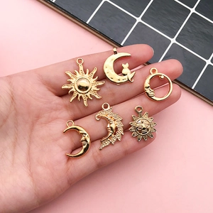 Detail of six gold celestial charms with sun and moon designs for DIY jewelry