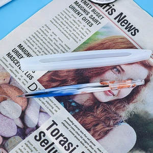 Close-up of translucent silicone ballpoint pen mold with a finished blue resin pen