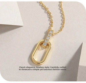 Macro detail of U-shaped gold necklace with micro-pave crystals and polished oval pendant