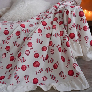 Christmas beige sofa throw with red ornaments, candy prints, and ruffled edges