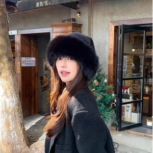 Chic black faux fur bucket hat featuring a fluffy, wide-brim design for winter warmth
