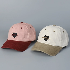 Close-up of heart patch embroidery and stitching on washed cotton baseball caps