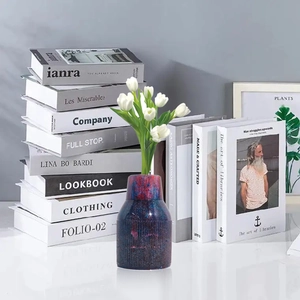 Navy blue star-patterned vase with vertical texture and white tulips on a desk