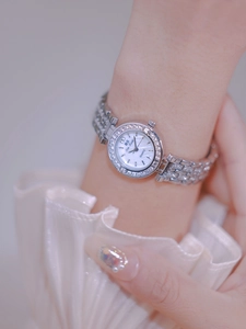 Close-up of luxury women's silver quartz watch with rhinestone bezel and mother-of-pearl dial