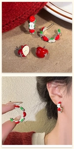 Detail of red enamel apple earrings with crystals on silver pins shown in pair and worn