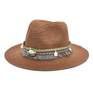 Detail of vintage brown straw fedora featuring ethnic beads, tassel, and turquoise stone