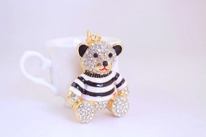 Macro detail of luxury striped bear keychain with shiny rhinestones and gold hook