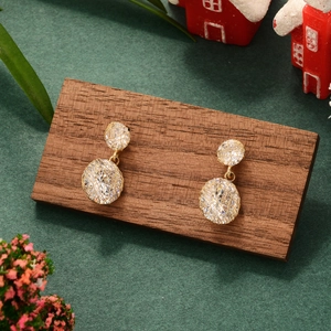 Elegant gold mesh earrings with sparkling cubic zirconia on a festive wooden display base