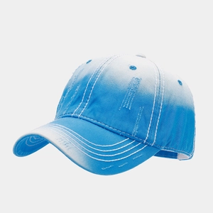 Detail of distressed baseball cap featuring blue and white gradient with bold stitching