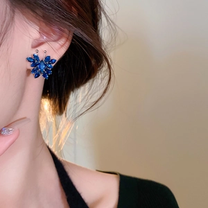 Close-up of elegant blue zircon butterfly earrings worn by a model for size and fit detail
