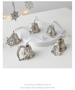 Close-up of vintage silver Christmas bells featuring snowflake, reindeer and angel wing charms