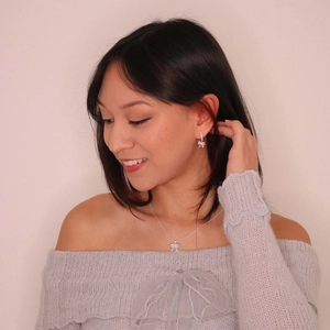 Elegant silver bow jewelry set with diamonds shown on model wearing off-shoulder sweater