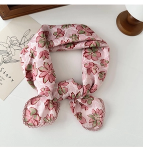 Detail of pink cotton linen scarf with green floral print and delicate lace edges