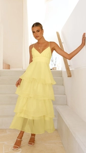 Detail of elegant bright yellow backless tiered evening gown with delicate straps