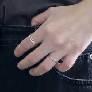 Detail of 925 sterling silver ring set featuring minimalist crisscross and textured bands