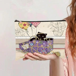 Détail d'une trousse à maquillage en toile avec motif chat et fermeture éclair noire