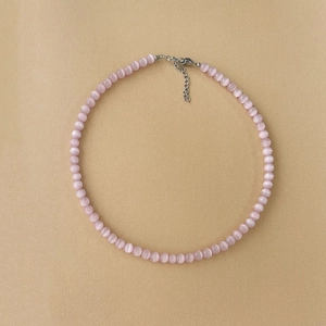 Macro detail of pink cat eye stone beads with silver adjustable lobster clasp and chain