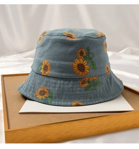 Detailed view of blue denim sun hat featuring yellow sunflower prints for toddlers