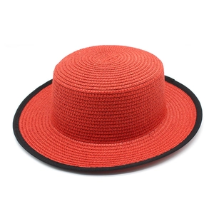 Modern red straw boater hat with flat top and black trim for summer sun protection
