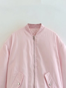 Close-up of pink satin bomber jacket featuring silver zipper and quilted inner lining
