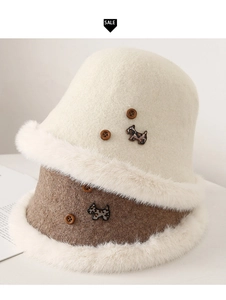 Dettaglio di cappelli invernali in lana con bordo in ecopelliccia e decoro bottone cane