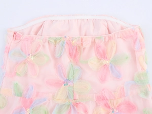 Détail de robe en tulle rose avec broderies florales 3D et bande de silicone antidérapante