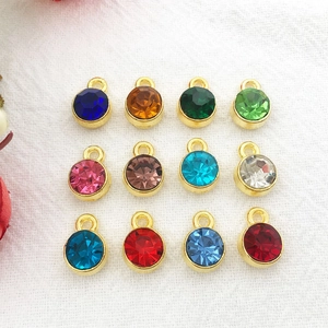 Set of twelve 7mm round gold-plated birthstone charms with colorful faceted crystals