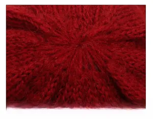 Close-up of the meticulous crown stitching on a red plush knit hat for elderly women