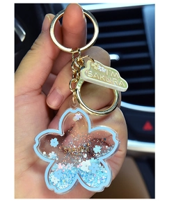 Macro view of cherry blossom acrylic keychain with blue floating sand and golden ring
