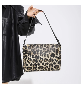 Dettaglio della borsa tote leopardata con cerniera dorata e tracolla sottile nera