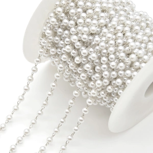 Macro view of white pearls with silver chain DIY jewelry roll for necklaces